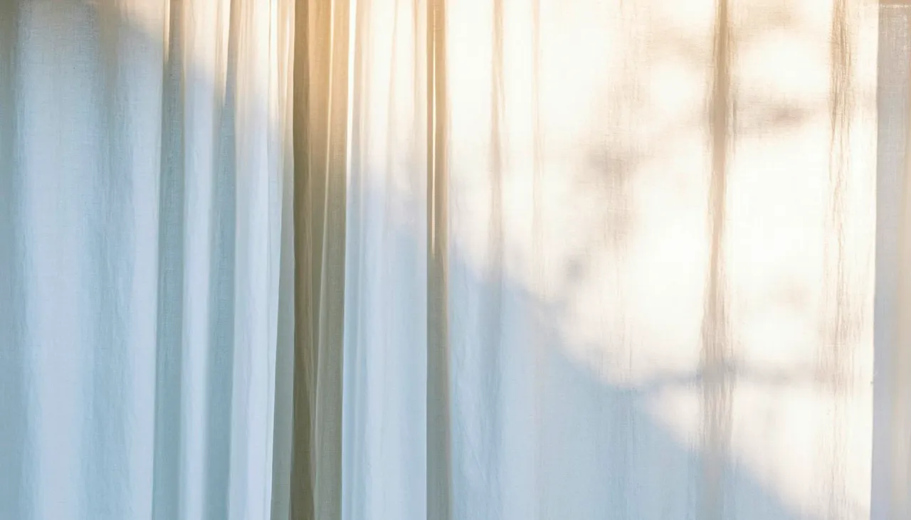 Cortinas blancas iluminadas por la luz de la mañana