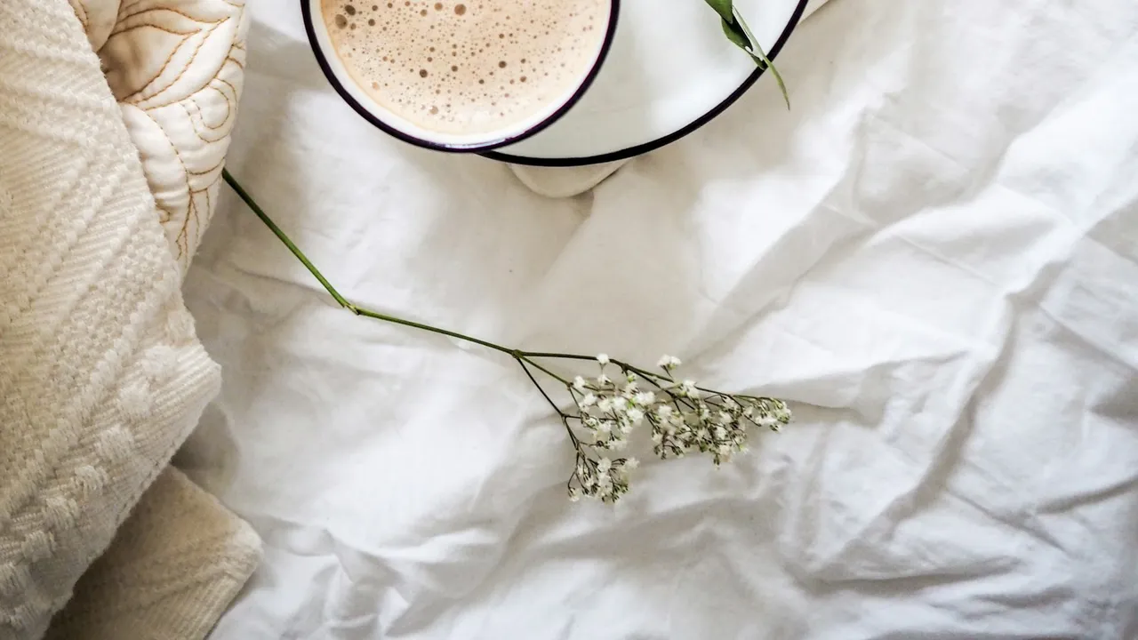 Taza blanca con café sobre una mesa con luz natural