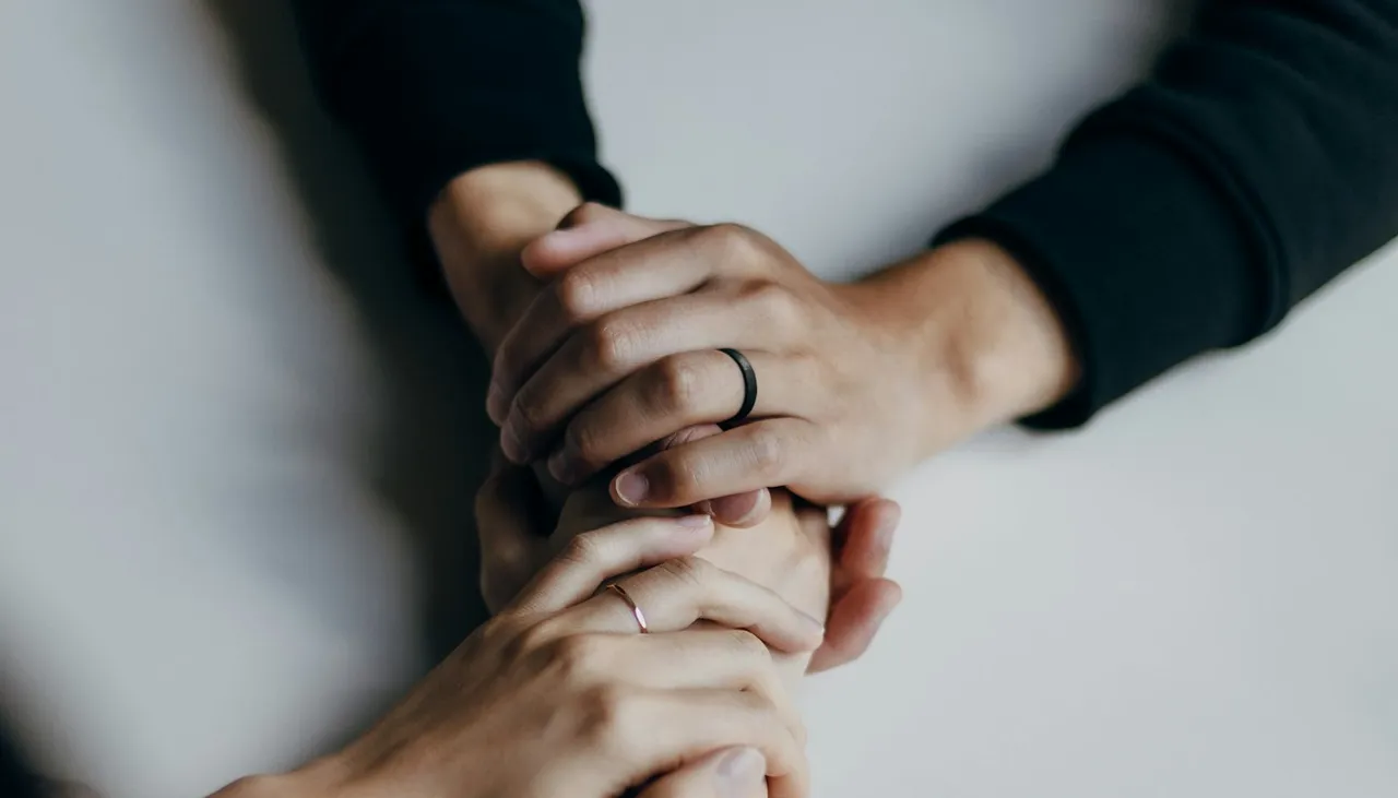 Dos personas tomadas de la mano en señal de apoyo